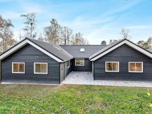 a home with a black house with a driveway at 14 person holiday home in Væggerløse in Marielyst