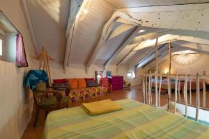 a bedroom with a bed and a couch in a room at La Casita in Beauvène