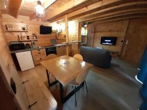 a kitchen and living room with a table and chairs at Le verger de Togne chalet 1 in Villafans +10 photos