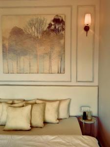 Un dormitorio con un cuadro encima de una cama con almohadas. en Nazaara - Mukteshwar - Mountain view and sunset from your bed, en Mukteshwar