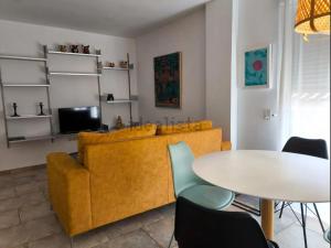 a living room with a yellow couch and a table at Plateria Catedral in Murcia