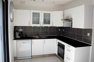 a white kitchen with a sink and a dishwasher at Maison "TY CASTERO" in Quiberon