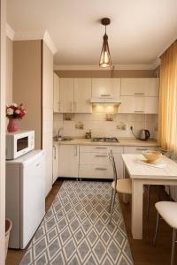 a kitchen with white cabinets and a table and a microwave at Family apartment comfort in Shymkent