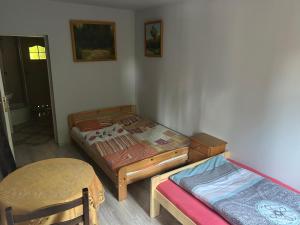 a room with two twin beds and a table at Łemkowo Pokoje Gościnne in Lutowiska +6 photos