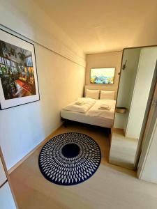 a small room with a bed and a rug at Jäggi 35 by Arosa Holiday in Arosa