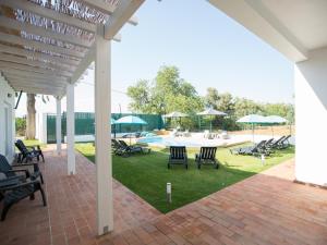 a patio with chairs and a pool with umbrellas at Tavira Monte in Tavira