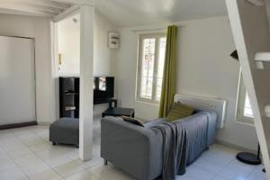 a living room with a couch and a chair at Duplex Mezzanine au calme Place de l'Horloge in Avignon