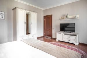 a bedroom with a bed and a flat screen tv at Sacvoyage Hotel in Almaty