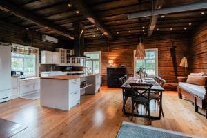 eine Küche und ein Wohnzimmer mit einem Tisch und einer Couch in der Unterkunft Lapland Heritage Villa in Ranua