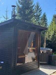 a small cabin with a large window on a deck at Tramonto Cabin in Vartop