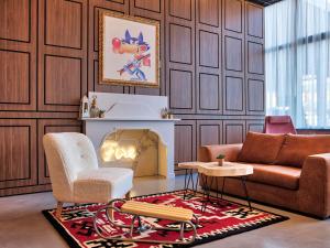 una sala de estar con un sofá y una silla en ibis Styles Sarajevo, en Sarajevo