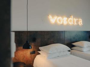 Un dormitorio con dos camas y un cartel que dice Vaticano. en ibis Styles Sarajevo, en Sarajevo 100 fotos más