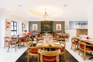 a restaurant with wooden tables and chairs and people sitting at tables at Tranquil Haven in Cape Town