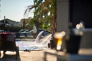 a water fountain in a pool with chairs at Apartament Horizon by Alz in Mamaia Sat/Năvodari