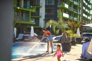 a woman and a child playing in a fountain at Apartament Horizon by Alz in Mamaia Sat/Năvodari
