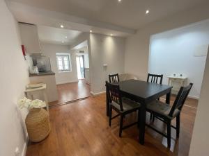 Central Lisbon Stay with Terrace في لشبونة: غرفة طعام مع طاولة وكراسي سوداء