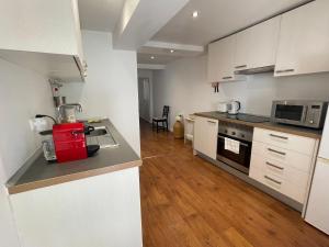 Central Lisbon Stay with Terrace في لشبونة: مطبخ بخزائن بيضاء وطاولة عمل +50 صورة