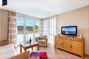 a living room with a flat screen tv and a couch at Ferienwohnung Strandblick 2 in Ueckeritz