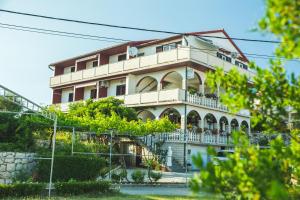 a large building with a balcony on a hill at Guesthouse Marija in Lopar
