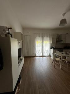 a kitchen and a living room with a table and chairs at B&B Alèsia in Montesilvano