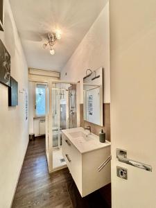 a white bathroom with a sink and a mirror at Maison du Citron in Vallecrosia +22 photos