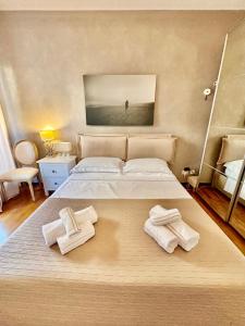 a bedroom with a large bed with towels on it at Maison du Citron in Vallecrosia