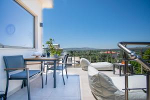 a dining room with a table and chairs on a balcony at ''Aetheria'' Rooftop Resort with sea view in Kremasti