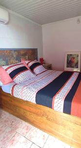 Un dormitorio con una cama grande en una habitación. en Meublés Le KANNISTEL, en Saint-Pierre