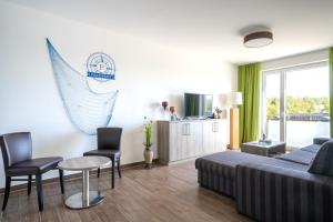 a living room with a couch and a table and chairs at City Park Apartments - Hafenruhe in Großpösna