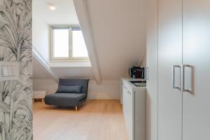 un soggiorno con una sedia e una finestra di Suites Mozart & Chopin by Toh Solution a Torino