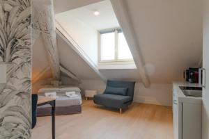 una camera da letto con un letto e una sedia in una stanza di Suites Mozart & Chopin by Toh Solution a Torino