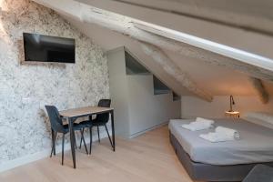 una stanza con un letto, una scrivania e una TV di Suites Mozart & Chopin by Toh Solution a Torino