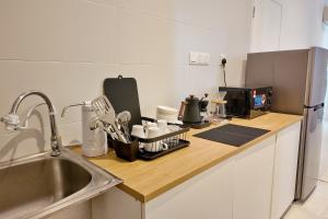 a kitchen with a counter top with a sink and a counter top at Kuching City Riverine Diamond by Bed and Brew Staycation in Kuching