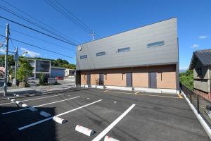 an empty parking lot with a building at LA-CHIC Stay 大津 in Ozu