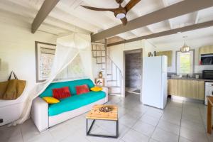 a living room with a couch and a table at Lodge 3 - Jasmin - Jacuzzi Privé in La Plaine
