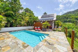 a swimming pool in the backyard of a house at Lodge 2 - Hibiscus - Jaccuzi Privé in La Plaine