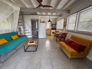 a living room with a couch and a table at Lodge 1 - Colibri - Jacuzzi Privé in La Plaine