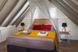 a bedroom with a canopy bed with towels on it at Lodge 2 - Hibiscus - Jaccuzi Privé in La Plaine +7 photos