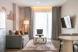una sala de estar con un sofá y una mesa en The Rich Grand Residence Sukhumvit, en Bangkok