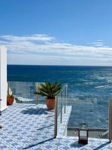 a walkway leading to the ocean with a potted plant at Esplanada do Ilhéu in Vila Franca do Campo