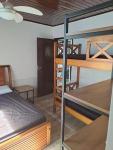 ein Zimmer mit zwei Etagenbetten und einem Tisch in der Unterkunft Casa praia fortaleza pé na areia in Ubatuba