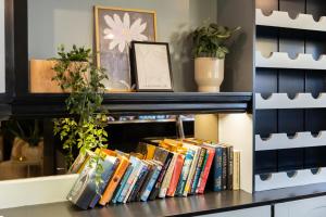 a shelf filled with books on a shelf with plants at BadHotel Noordwijk in Noordwijk