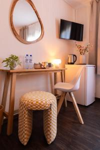 a room with a table and a chair and a mirror at BadHotel Noordwijk in Noordwijk