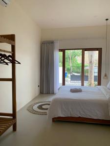 a bedroom with a large bed and a large window at Permata Villas Lombok in Kuta Lombok