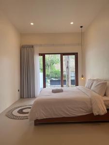 a bedroom with a large bed and a large window at Permata Villas Lombok in Kuta Lombok