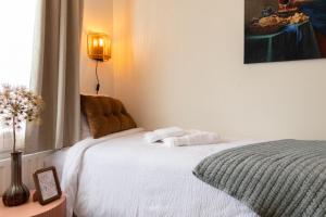 a bedroom with a white bed and a window at BadHotel Noordwijk in Noordwijk