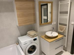 a bathroom with a washing machine and a sink at Do lesa - Into the Woods in Vysoké Tatry