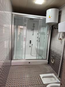 a shower with a glass door in a bathroom at Hostel Azizjon in Samarkand