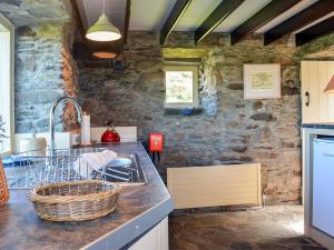 a kitchen with stone walls and a counter with a sink at 1 Bed in Cape Clear Island oc-ii16739 in Lissarnona