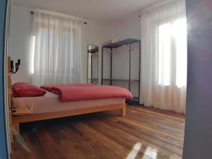 a bedroom with a large bed with red sheets at ALPINO B&B in Chiesa in Valmalenco